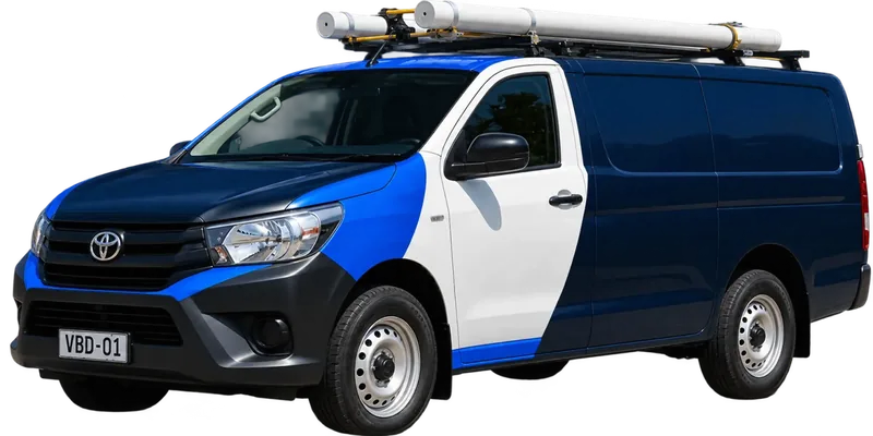 A licensed Como plumbing van loaded with pipe on the roof rack
